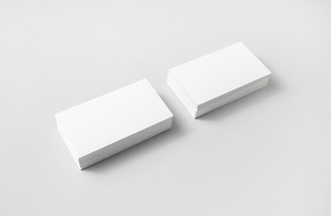 Photo of blank business cards with soft shadows on paper background. For design presentations and portfolios.