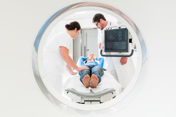 Arzt, Patientin und Krankenschwester bei CT Tompgraphie im Krankenhaus, Bild durch die Röhre des...