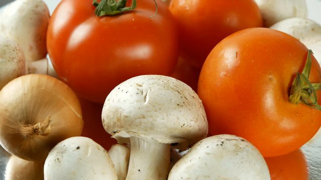 4K UHD footage of various vegetables slow rotating with tomato, mushrooms, onions, cucumbers and other