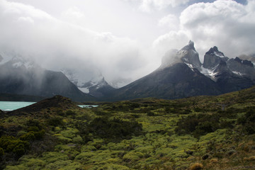 ośnieżone górskie szczyty  torres del paine w chmurach i turkusowe jezioro