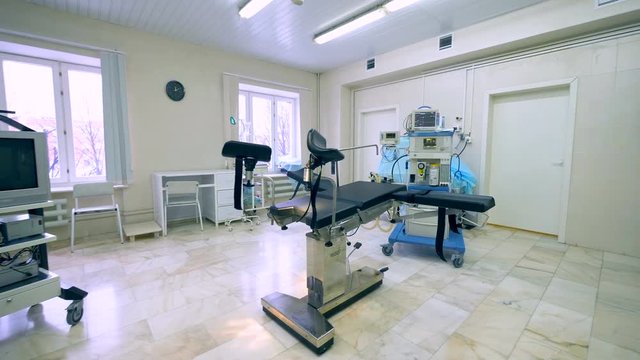 Side view of an obstetrics hospital room with professional equipment and examination chair