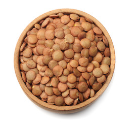 Pile lentil in wooden bowl isolated on white background. Top view.