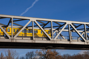 BERLIN, GERMANY - FEBRUARY 22, 2017: Yellow u-bahn train crossing the metal bridge