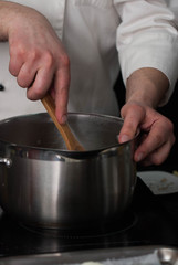 Fototapeta na wymiar Chef Hands Mixing Pancake Dough in Metal Bowl. Mixing Components. Baking Pancakes in Progress. Vertical Image.
