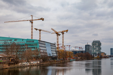 Tower cranes and building construction sites. Berlin, Spree river view.