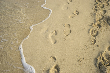 Fototapeta na wymiar Mediterranean scene, shore of the Mediterranean Sea with barefoot footprints of people in summer