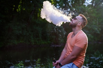 Men with beard smoke electronic cigarette outdoor