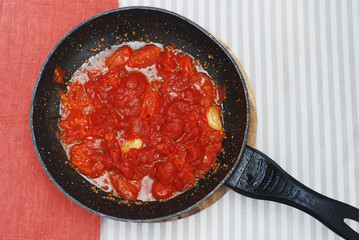 Tomatoe Sauce in Black Pant Top view. Food Preparing with Orange Napkin.