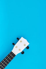 Musical instrument on a blue background. The white ukulele is on a blue background. Flat Lay Pattern