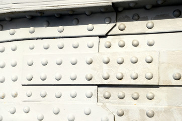 Closeup on elder gray steel structure with a lot of rivets.