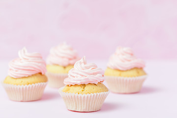 Cupcake decorated with pink buttercream on pastel pink background. Sweet beautiful cake. Horizontal banner, greeting card for birthday, wedding, women's day. Close up photography. Selective focus