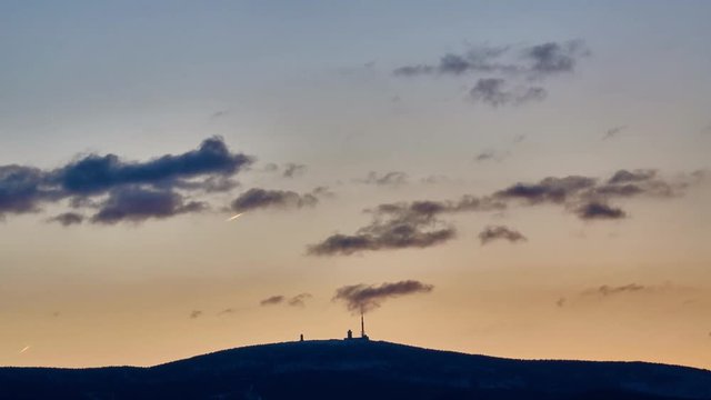 Mount Brocken silhouette at sunset in the winter evening. Time lapse. 4K.