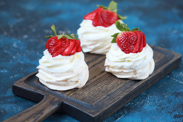 Three homemade mini cakes with meringue (pavlova) and cream cheese with strawberries. Selective focus.
