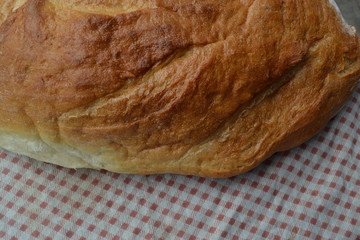 Bread. A loaf of bread. Freshly baked bread. Kitchen. Tablecloth. Delicious. Close-up. Horizontal