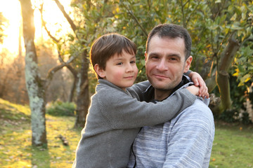 padre e hijo abrazados en la naturaleza al atardecer