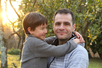 niño mirando feliz a su padre al que está abrazado
