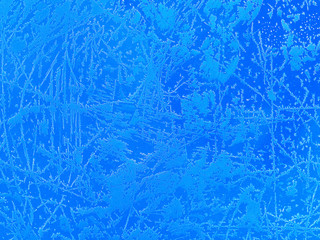 Frosty natural pattern on a blue background, metal surface in the winter season