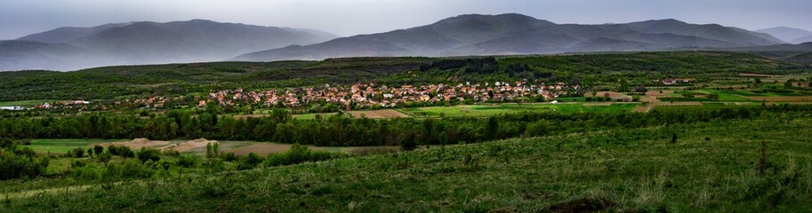 Fototapeta na wymiar Village of Shishkovtsi, Bulgaria, During the Spring with Misty Mountains in the Back