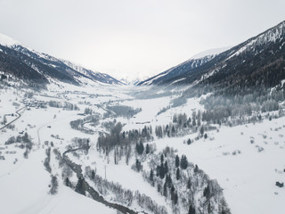 Aerial view of valley in Swiss mountains, snow covered landscape