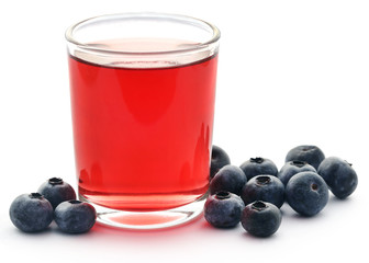 Group of fresh blueberries with juice in a glass