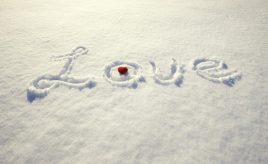 word love and red heart on snow
