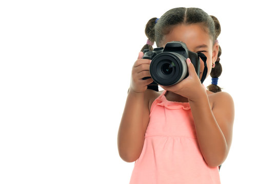 Multiracial small girl taking pictures with a professional camera - Isolated on white