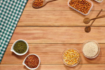 Healthy grain food and seeds in a wooden spoon and Glass white bowl on wood background with a Table Cloth. Top View. Copy Space.