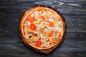 Appetizing pizza with tomato, chicken, paprika and mushrooms, top view. Delicious Italian food, restaurant menu photo