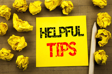 Fototapeta premium Handwriting text showing Helpful Tips. Business concept for Help in FAQ or Advice, written on sticky note paper on the vintage background. Folded yellow papers on the background