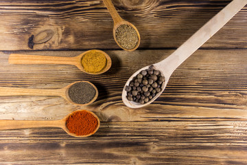 Assorted spices in wooden spoons on a table