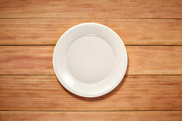 Empty Plate, Fork, Knife and Table Cloth on wooden background. Top View with Text Space