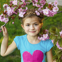 Pretty little girl in blossom cherry garden on beautiful spring day	