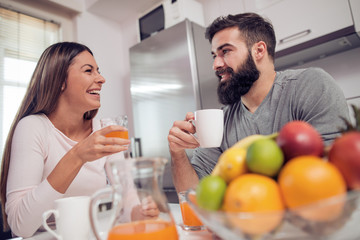 Young happy couple having breakfast together.