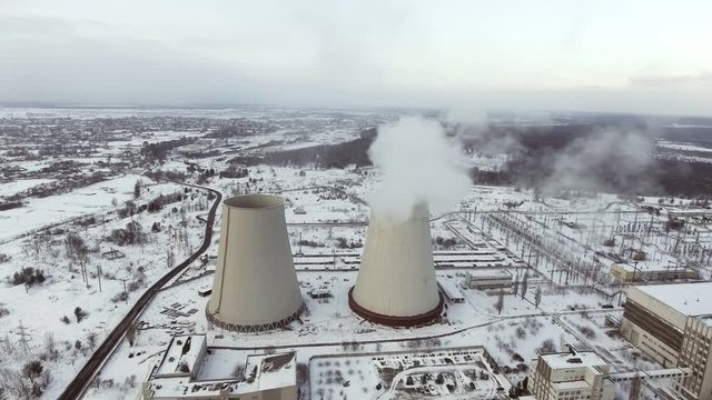 Flying over the large pipe plant for the production of thermal energy Aerial. Breathtaking Aerial Flyover Of Factory, Smoke Stack, Industrial Energy plant.