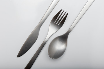 Metal inox cutlery on bright gray table