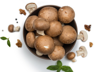 sliced and whole mushrooms on white isolated background with basil and pepper