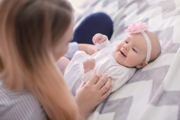 Young mother and her baby on bed at home