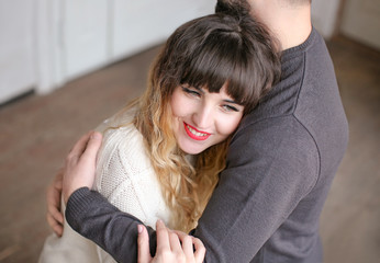 Young loving couple hugging indoors