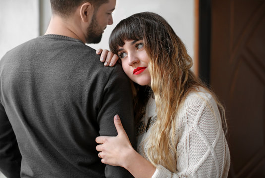 Young woman hugging her boyfriend indoors