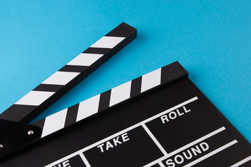Fototapeta na wymiar Movie clapper board on blue background with copy space, close-up, view from above. Cinema and movie time concept