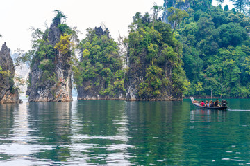 Fototapeta na wymiar Significant karst formations in the national park Khao Sok rise above the Cheow Lan Lake. The Khao Sam Kler rocks of the Khao Sok national park are national symbols