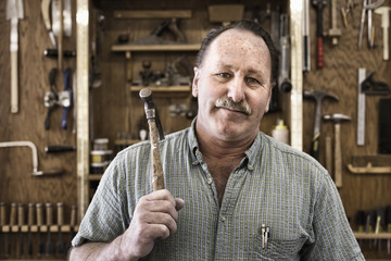 Portrait of carpenter with work tools at workshop