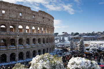 Snow covers the streets of Rome, Italy. Piazza del Colosseo comes alive with hundreds of people who went to celebrate the event. - obrazy, fototapety, plakaty