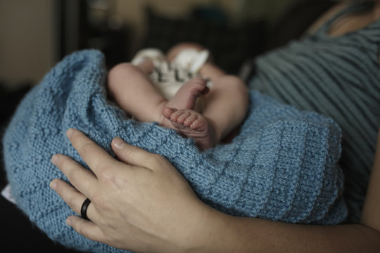 Midsection Of Mother With Newborn Son At Home