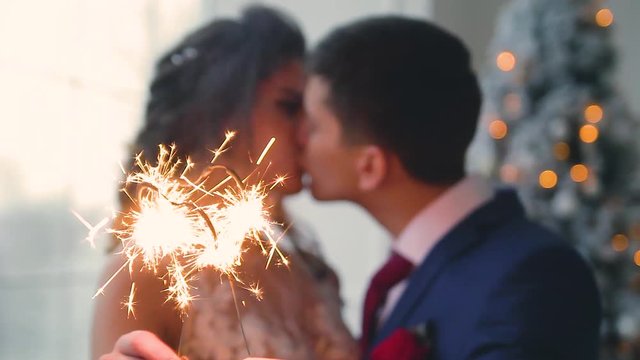 Beautiful young loving wedding couple in new year interior with Bengali lights