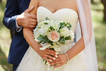 Obraz na płótnie Canvas Wedding couple, groom and bride holding wedding bouquet of fresh flowers. Marriage concept