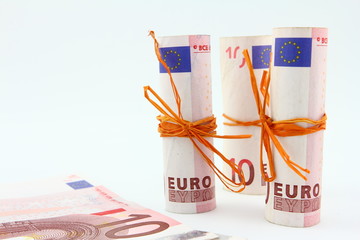 Zwinięte banknoty EURO przewiązane wstążką na jasnym tle