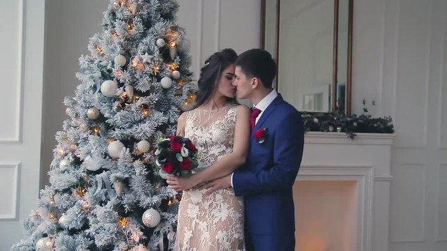 Beautiful young loving wedding couple in new year interior with Bengali lights