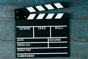 Obraz premium Movie clapper board. Black clapperboard on blue wooden background with copy space, close-up. Cinema and movie time concept