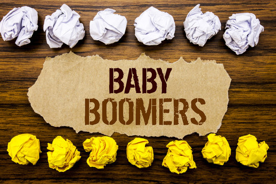 Conceptual hand text word Baby Boomers. Business concept for Demographic Generation Written on sticky note, wooden with sticky, many folded paper white and yellow for difference or collaboration